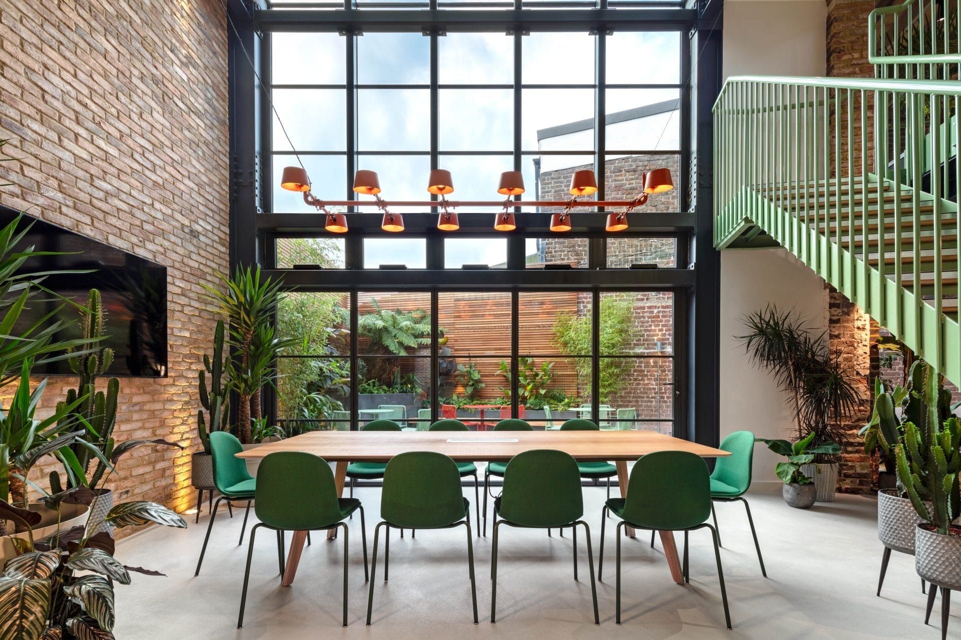 Interior design of a commercial office space in Brighton featuring green chairs and a table. Stickland Wright Architecture and Interior Design