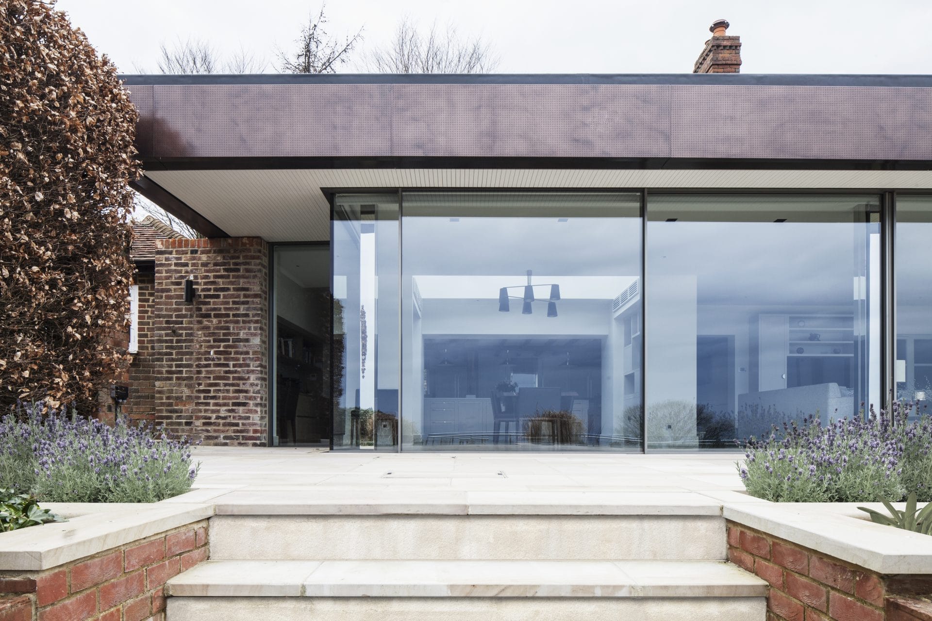 A modern residential home extension featuring glass walls and steps. Stickland Wright Architecture and Interior Design